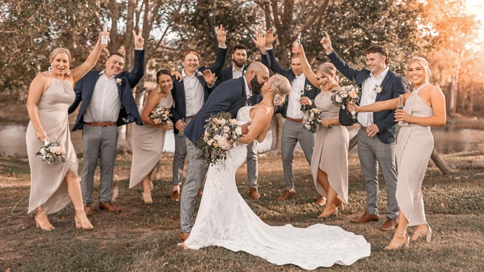 bride-groom-kissing-with-bridal-party-cheering