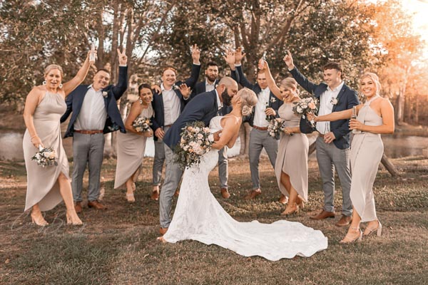 Bride & groom with bridal party celebrating photo