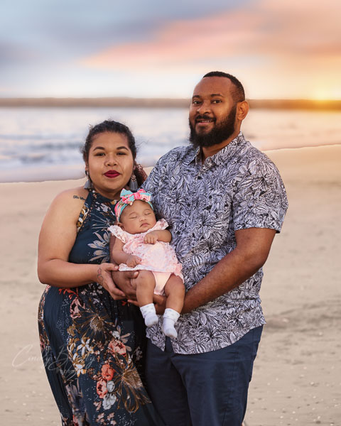 Family photo of mum, dad & baby on beach