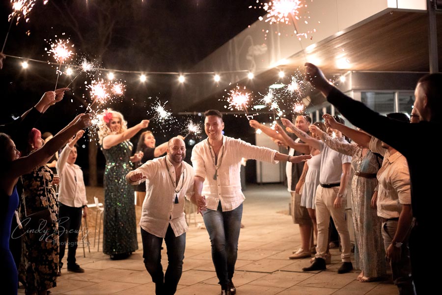 Gay wedding couple exit with sparkler