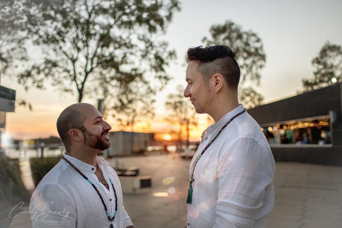 Groom & groom looking at each other with sunset background