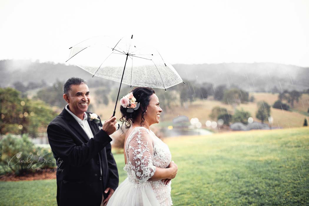 Wedding couple portrait with umbrella in rain