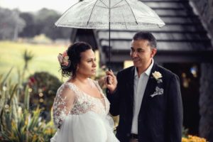 Wedding couple portrait with umbrella in rain